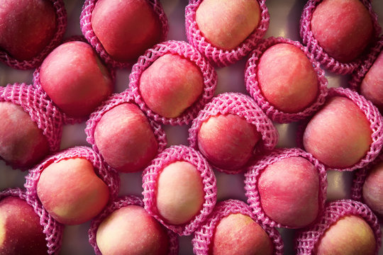 Fresh Fuji apples in box on display for sale.