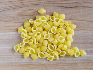 Raw pasta on a wooden bakground