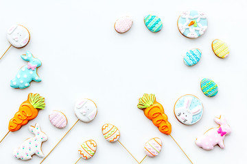 Sweets for celebrate Easter. Gingerbread in shape of easter bunny and easter eggs. White background top view copy space