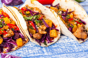Mexican pork tacos with vegetables and pumpkin. Tacos on wooden blue rustic background. Top view.