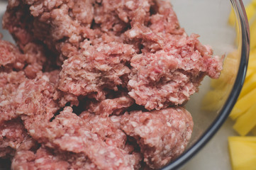 Sliced potato for soup and meat stuffing for making meatballs. Soup with meatballs and pasta prepear in process.