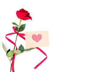 Valentine's day congratulation. Red rose and greeting card with heart sign on white background top view copy space
