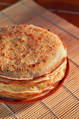 Close-up pancakes on plate on  dark wooden background.
