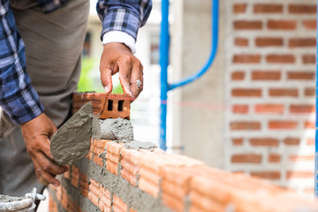 Brickwork walls, technicians are forming brick walls with mortar (cement, sand) by using a trowel...