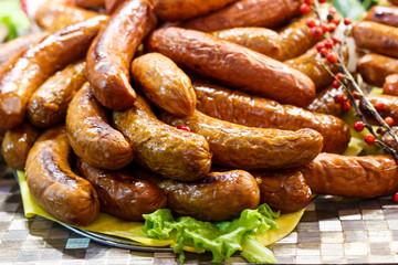 Freshly cooked sausages on a grill close-up. A background of sausages cooked on charcoal.