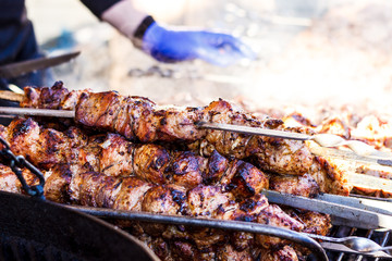 The process of cooking shish kebab on a metal grill in the open air.Grilling shashlik on barbecue...