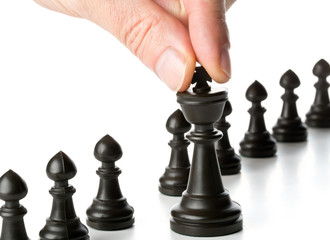 Business man moving chess figure in front of other chess figures