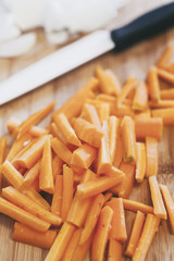 Freshly chopped carrots on wooden table.