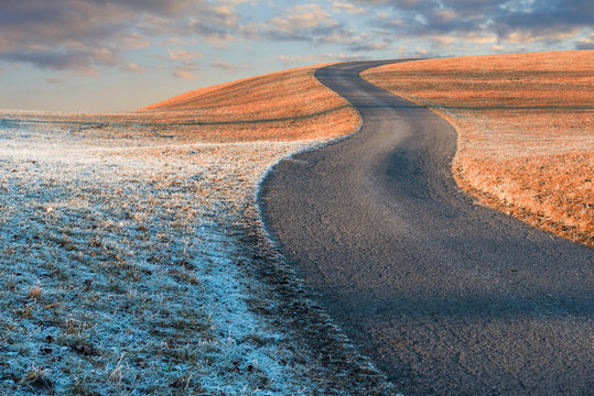 gewundene Stra&szlig;e auf den H&uuml;gel, frostige Herbstlandschaft und Wolkenhimmel