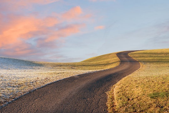 gewundene Stra&szlig;e auf den H&uuml;gel, frostige Landschaft mit Morgenrot