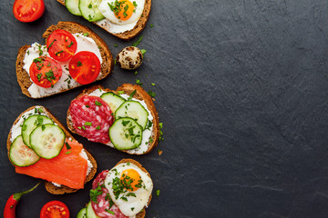 Homemade bruschetta. Mini sandwiches. Traditional spanish tapas on dark table. Brushetta set.