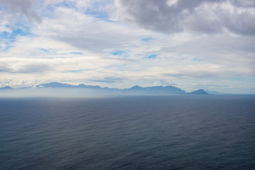 South Africa coast with scenic mist and fog over the ocean, Cape Agulhas, Cape Peninsula, Cape Town, travel destination. Dramatic sky in winter.