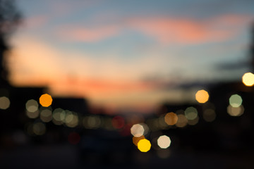 Defocused traffic and city lights on urban big street at dusk.