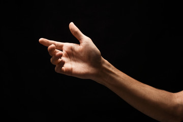 Male hand holding virtual smartphone isolated on black