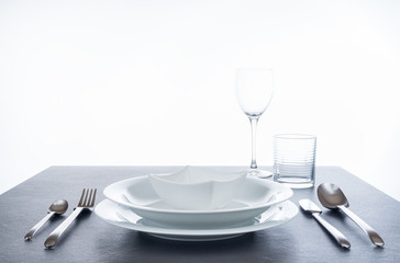 Besteck und Geschirr für Menü auf spiegeldem Granittisch, Hintergrund