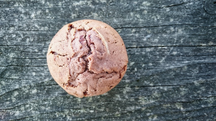 Homemade cupcake or muffin on a weathered wooden board.