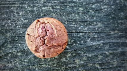 Homemade cupcake or muffin on a weathered wooden board.