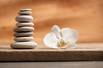 flower and pyramid of stones on a wooden background