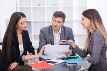 Meeting with agent in office, buying renting apartment or house, buyers of real estate ready to conclude a deal, family couple shaking hands with realtor after signing documents for realty purchase