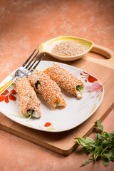salmon rolled up with sesame seeds ricotta and arugula, selective focus
