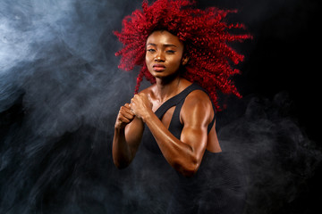 A strong athletic woman on black background wearing in sportswear, fitness and sport motivation. Sport concept with copy space.
