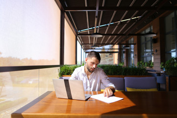 Inventory strategist working with laptop at cafe table.