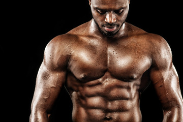 Fototapeta na wymiar Sports wallpaper on dark background. Power athletic guy bodybuilder.