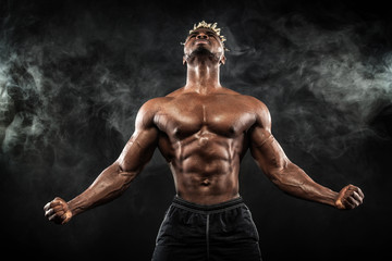 Naklejka na ściany i meble Sports wallpaper on dark background. Power athletic guy bodybuilder.