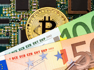 Digital cryptocurrency gold bitcoin, electronic computer component and euro banknotes. Business concept of new virtual money