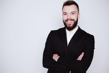 Handsome smiling modern business man in black suit on white background isolated. Guy looking on camera.