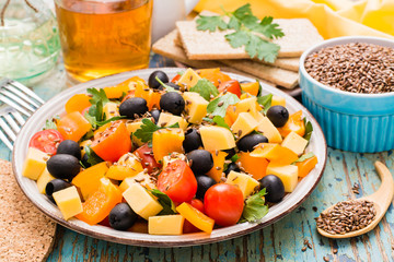 Greek salad and flax seeds on a wooden table