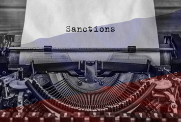 Sanctions, a printed word on an old vintage typewriter. background flag of russian federation