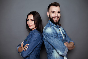 Beautiful and happy young couple in love or family in casual wear having fun and making fun of each...