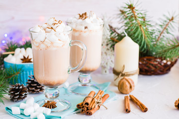 Hot cocoa with marshmallow and ground cinnamon in glasses on the table in Christmas decorations