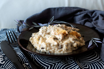 Tasty risotto with chicken, fresh herbs vegetables on a white plate