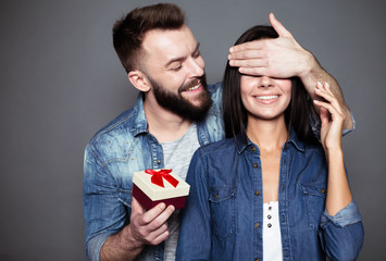 The gift will be a second. A young man gives his beloved a present and closes her eyes with a...