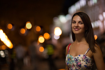 Beautiful woman is walking in the night city.