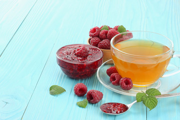 healthy background. raspberry with raspberry jam and tea on blue wooden table