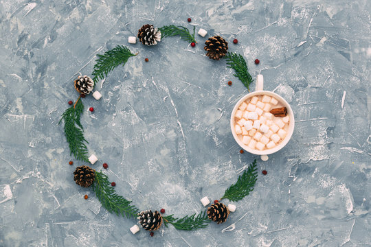 Hot chocolate with marshmallows and a fir and pine cone arrangement