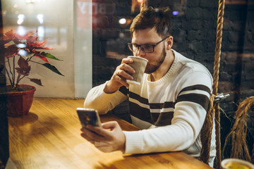 man drink tea and check his phone