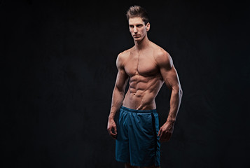 Obraz na płótnie Canvas Shirtless muscular male over dark background.