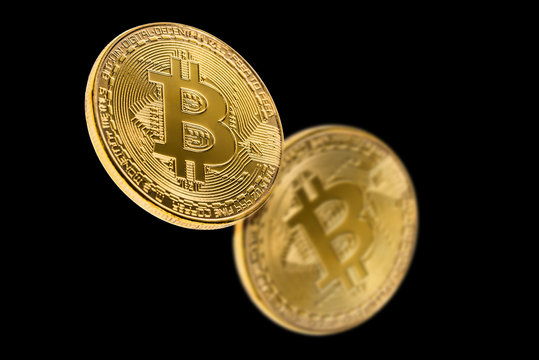 Golden bitcoin isolated on a black background with reflection. Cryptocurrency concept.
