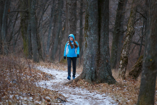 Young Woman Walking On Snowy Trail In Winter Park