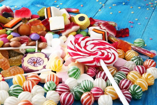 candies with jelly and sugar. colorful array of different childs sweets and treats on light blue wood background