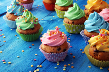 Tasty cupcakes on wooden background. Birthday cupcake in rainbow colors