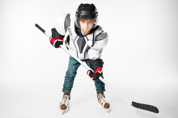 Fototapeta premium Young hockey player in safety gear with stick looking straight aggressively