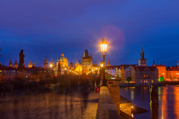 Fototapeta premium Summer night walking by illuminated Charles Bridge, Prague, Czech Republic