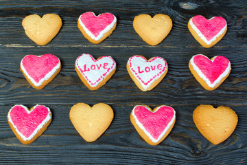 Fototapeta na wymiar Decorated of Valentines Day. Many small cookies with glaze, in the shape of a heart with the inscription 