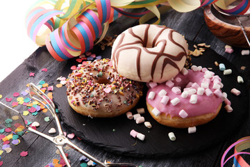 assorted donuts with chocolate frosted, pink glazed and sprinkles donuts.