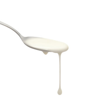 Fresh yogurt on a spoon isolated on white. Delicious yogurt drips from the spoon. Liquid drops